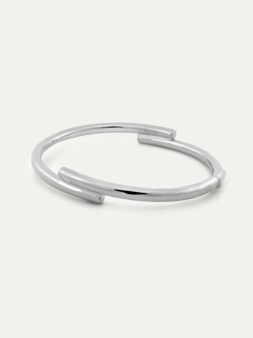 A polished silver open cuff bracelet with a modern design and with engraved Chinese character 心, displayed on a clean off-white background.