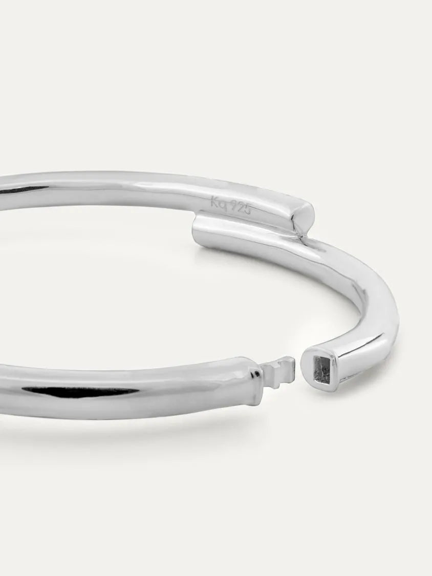 A polished sterling silver open cuff bracelet with a modern design, displayed on a clean off-white background.