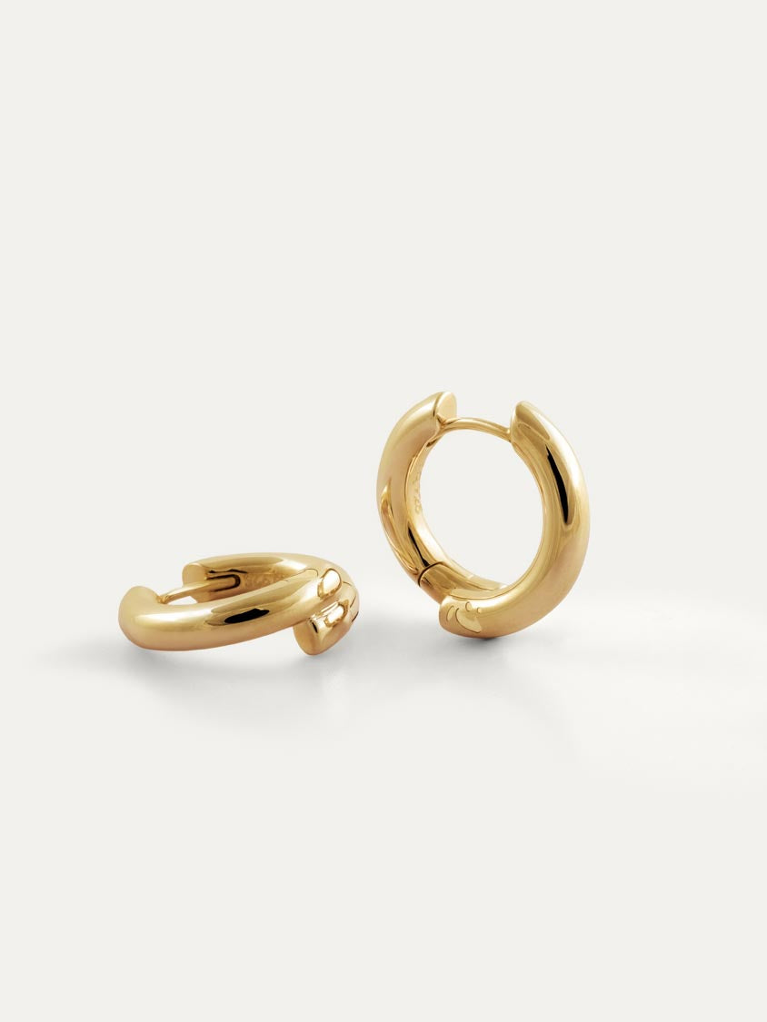A pair of polished 18k gold vermeil huggie hoop earrings with engraved Chinese character 心, displayed on a clean off-white background.