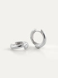 A pair of polished silver hoop earrings on a clean, light off-white background.