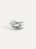 A polished sterling silver ring with a modern, open, double-loop design, photographed on a clean, light off-white background.